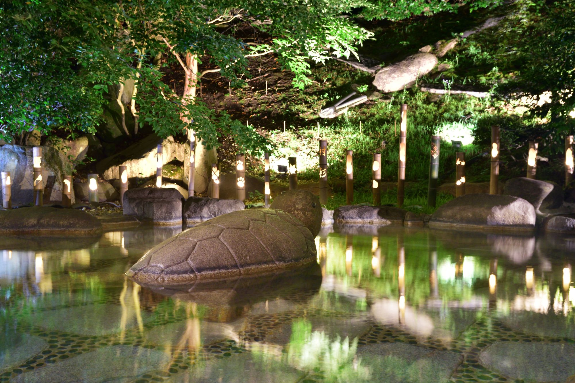 女性露天風呂：凛とした佇まいの竹灯りが並ぶ幻想的な夜の露天全景
